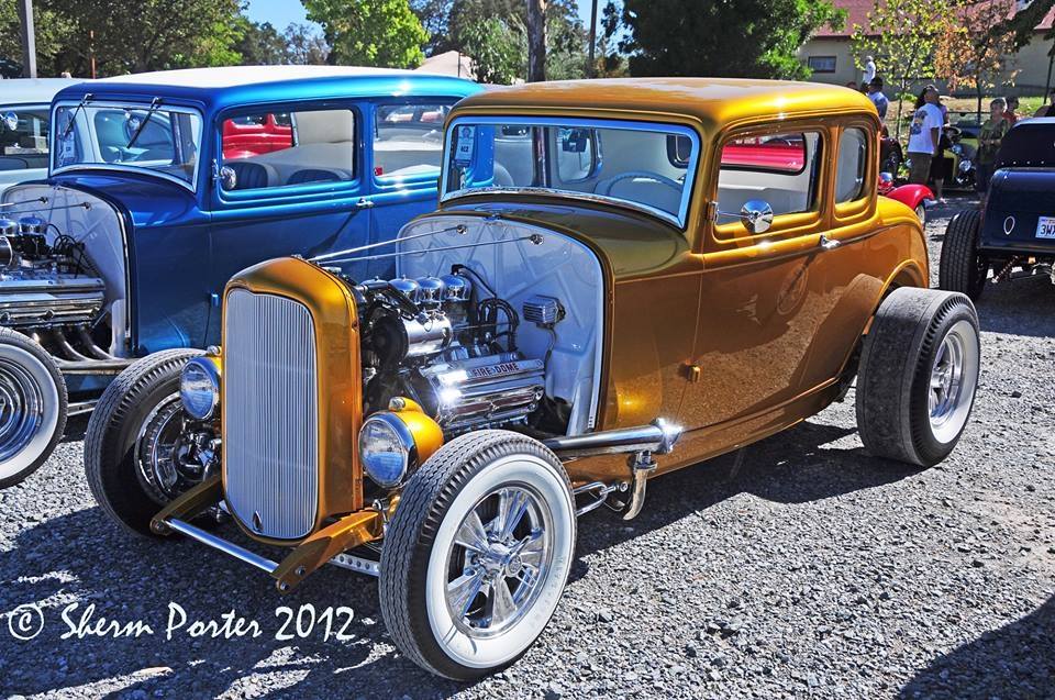 Gold 1932 five-window coupe hot rod with a blown engine, at a car show