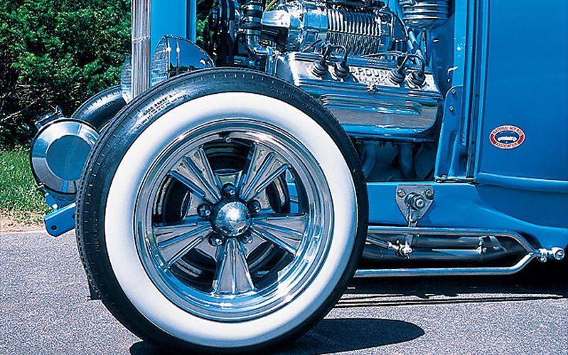 Radir wheel and whitewall slick mounted on a blue hot rod, front wheel and engine detail