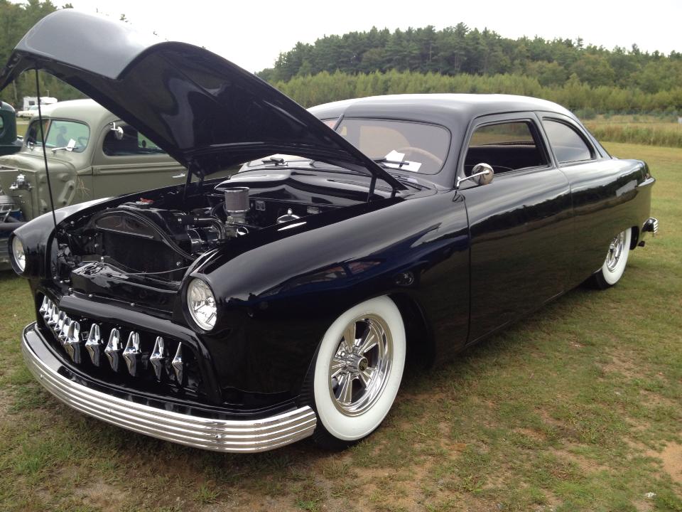 Black chopped custom kustom car with whitewalls, at a car show