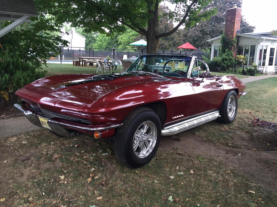 Maroon C2 Corvette Sting Ray convertible in a yard