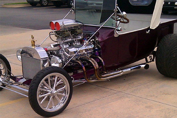 Purple T-bucket hot rod with polished wheels, engine bay detail