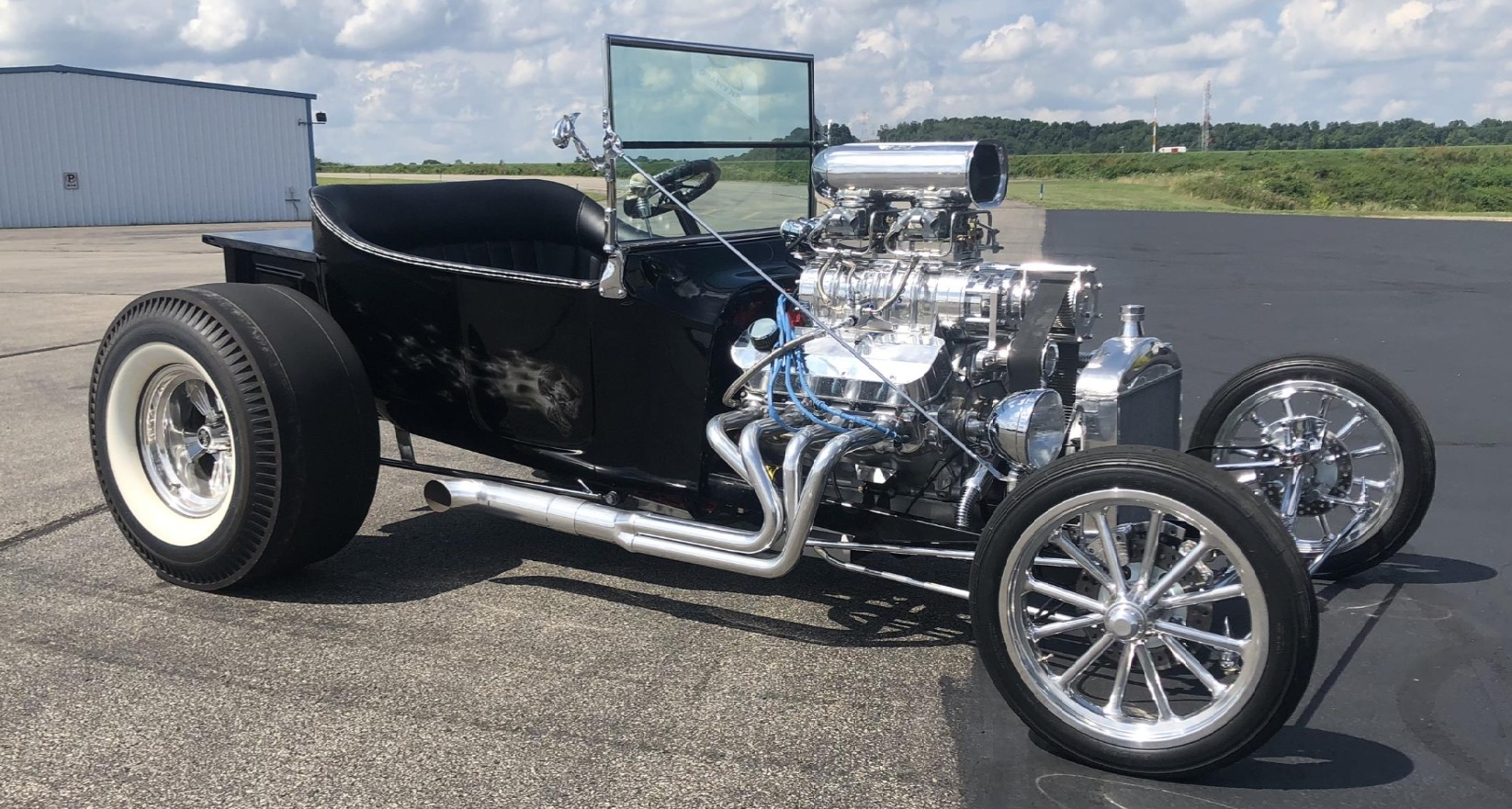 Black T-bucket hot rod with a big blower, fitted with Radir wheels